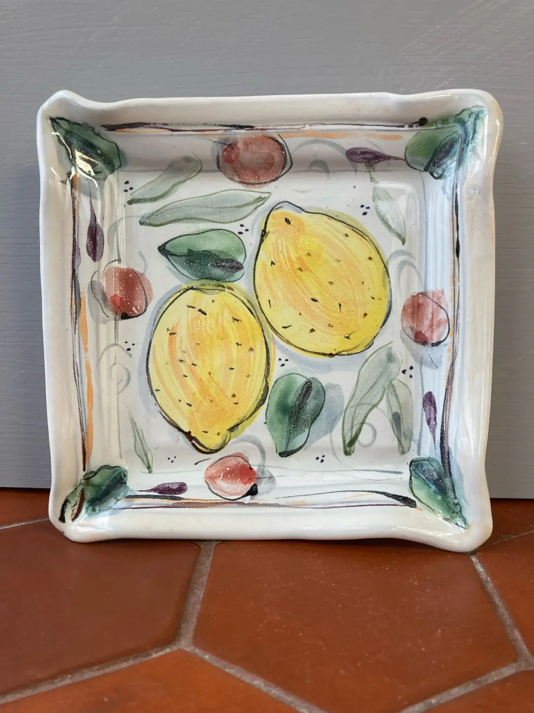 Square plate with lemons and cherries.