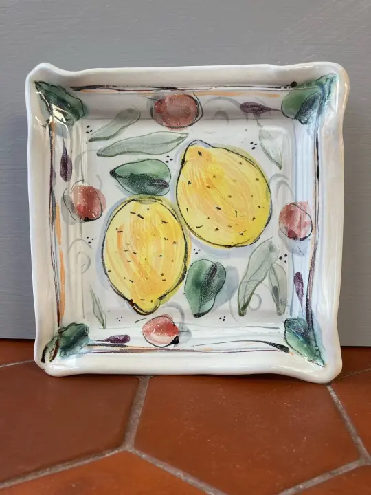 Square plate with lemons and cherries.
