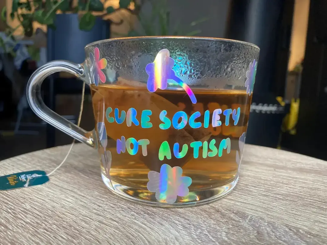 "Cure society, not autism" mug