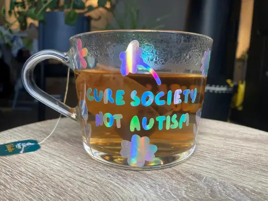"Cure society, not autism" mug