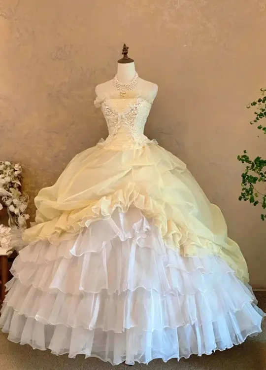 Light yellow strapless ball gown with a cinched waist and a voluminous puffy skirt; bridal gown R7308