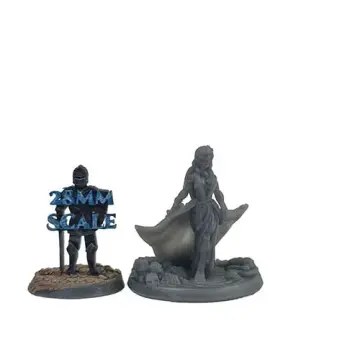 A photograph of an unpainted, 3D-printed grey resin miniature of a female vampire with a flowing cape, standing on a base littered with skulls and bones. To her left is a smaller, dark miniature with blue text reading "28MM SCALE" overlaid to demonstrate the size comparison.