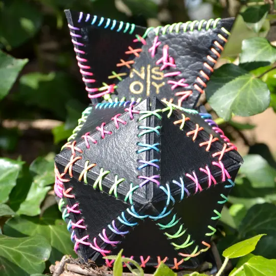 Handmade black leather dice bag stitched with rainbow thread.